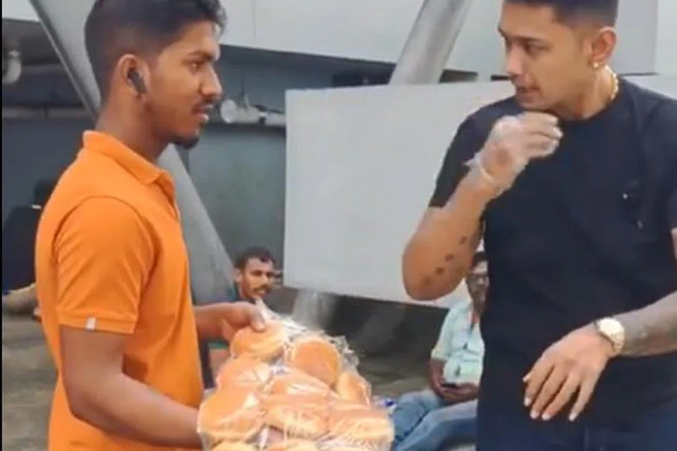 Encik Muhamad Iqbal Abdul Razak mengagihkan kepada pekerja hijrahan kira-kira seribu biji roti burger yang sepatutnya digunakan untuk penjualan semasa pesta perdagangan Trifecta Fest yang dibatalkan pada saat-saat akhir.