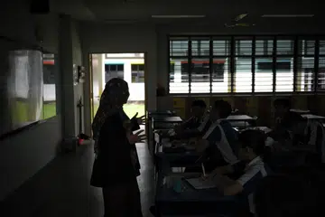 Pelajar Sekolah Menengah Jurong West tetap meneruskan pelajaran meskipun dalam suasana malap dan panas ketika melalui simulasi kuasa elektrik ‘terputus’ sempena Hari Pertahanan Mutlak pada 15 Februari.