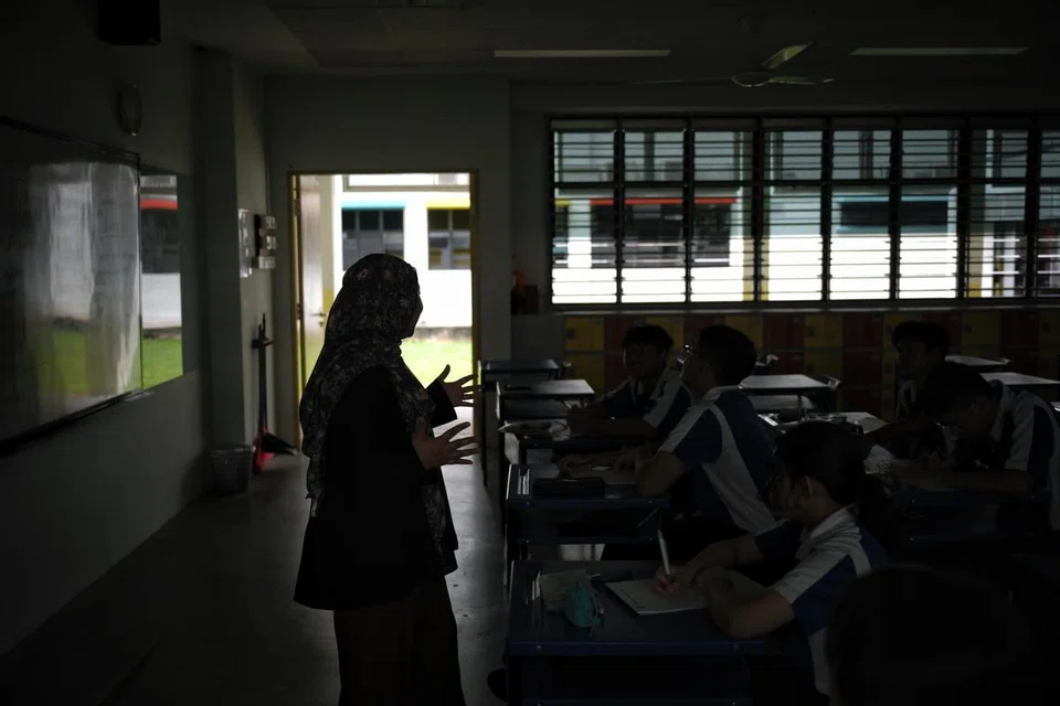 Pelajar Sekolah Menengah Jurong West tetap meneruskan pelajaran meskipun dalam suasana malap dan panas ketika melalui simulasi kuasa elektrik ‘terputus’ sempena Hari Pertahanan Mutlak pada 15 Februari.