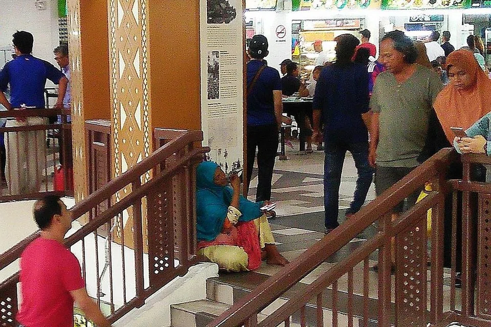 MENAGIH SIMPATI MASYARAKAT SINGAPURA: Wanita yang mendakwa dari India ini menghulur tangan meminta sedekah daripada pengunjung Pasar Geylang Serai, sementara seorang wanita dari Bangladesh (atas) mengemis di jejatas yang menghubungkan Joo Chiat Complex dan bangunan pasar itu sambil memangku anak kecilnya. - Foto-foto SAINI SALLEH