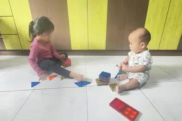 BERMAIN DENGAN ADIK: Anak-anak penulis, Munawwarah Mohammad Hanafi (kiri) dan Hamzah bermain bersama. 