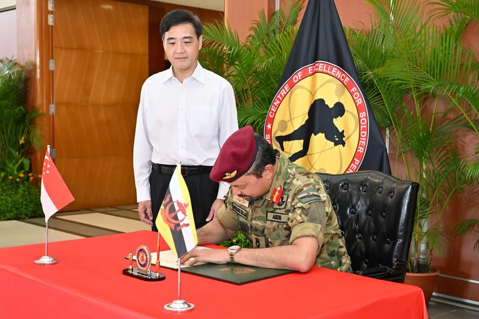 Putera Mahkota Brunei, Putera Al-Muhtadee Billah (kanan), menandatangani buku tetamu di Pusat Kecemerlangan Prestasi Askar (CESP), diiringi Menteri Negara Kanan (Pertahanan), Encik Heng Chee How (kiri).