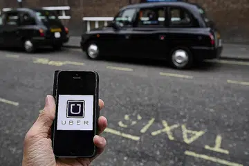 MANFAATKAN PELUANG KERJA BEBAS: Satu contoh gambar menunjukkan logo aplikasi Uber dipaparkan pada telefon mudah alih di pusat bandar London, Britain, di mana peluang pekerjaan menanti. - Foto REUTERS