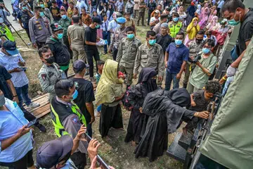 TIDAK DITERIMA: Pelarian Rohingya yang baru tiba, diarah  menaiki trak untuk dipindahkan ke pusat perlindungan sementara, selepas penduduk tempatan menolak kehadiran mereka di Banda Aceh pada 11 Disember. 