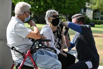 AMBIL DOS PENGGALAK: Jururawat Kevin Grellman memberi dos penggalak ketiga vaksin Pfizer Covid-19 kepada Cik Armida Gomez, 81 tahun, sementara suaminya Jose Gomez, 80 tahun, menunggu gilirannya di Pasadena, California, bulan lalu. - Foto AFP