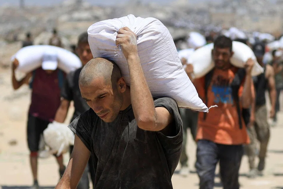 Rakyat Palestin mengangkat bekalan bantuan yang masuk ke Gaza melalui Israel, di Beit Lahia, di utara Gaza pada 1 Ogos 2025.