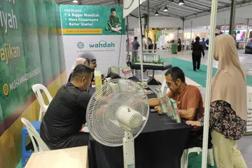Kakitangan Persatuan Muhammadiyah sedia berkongsi tentang khidmat kebajikan, dakwah dan pendidikan persatuan di bazar Eco Harmony Fest 2024 di Bedok.