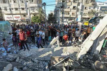 Warga Palestin berkumpul di tapak serangan udara Israel ke atas sebuah sekolah yang jadi tempat perlindungan mereka yang hilang tempat tinggal.