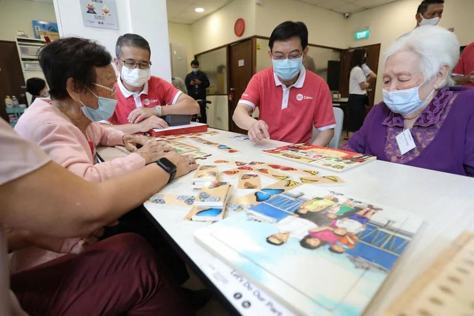 INTERAKSI DENGAN GOLONGAN MEMERLUKAN: Encik Heng Swee Keat (dua dari kanan) dan Encik Edwin Tong (dua dari kiri) berinteraksi dengan peserta di pusat sukarela SG Cares Volunteer Centre di Geylang. - Foto MCI