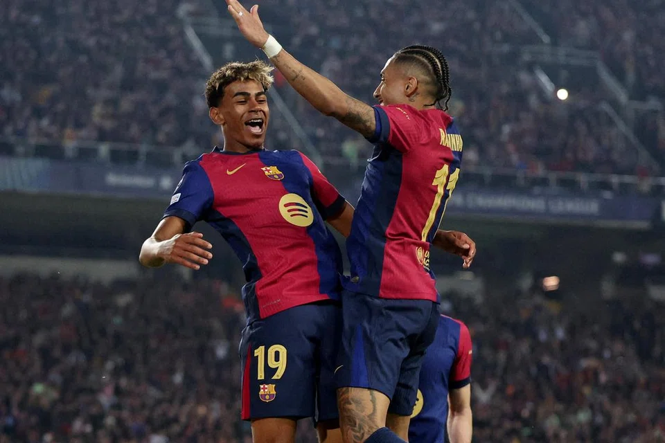 Penyerang Lamine Yamal (kiri) ,dan Raphinha meraikan jaringan keempat Barcelona dalam kemenangan 4-0 ke atas Borussia Dortmund.      