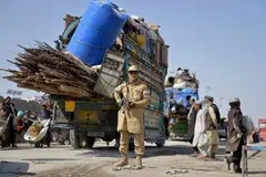 Seorang anggota keselamatan Taliban berkawal ketika pelarian Afghanistan yang diusir dari Pakistan tiba di lintasan sempadan antara Afghanistan dengan  Pakistan, di daerah Spin Boldak di wilayah Kandahar pada 27 Oktober 2025.
