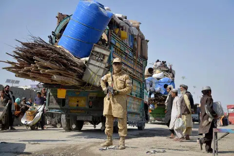 Seorang anggota keselamatan Taliban berkawal ketika pelarian Afghanistan yang diusir dari Pakistan tiba di lintasan sempadan antara Afghanistan dengan  Pakistan, di daerah Spin Boldak di wilayah Kandahar pada 27 Oktober 2025.