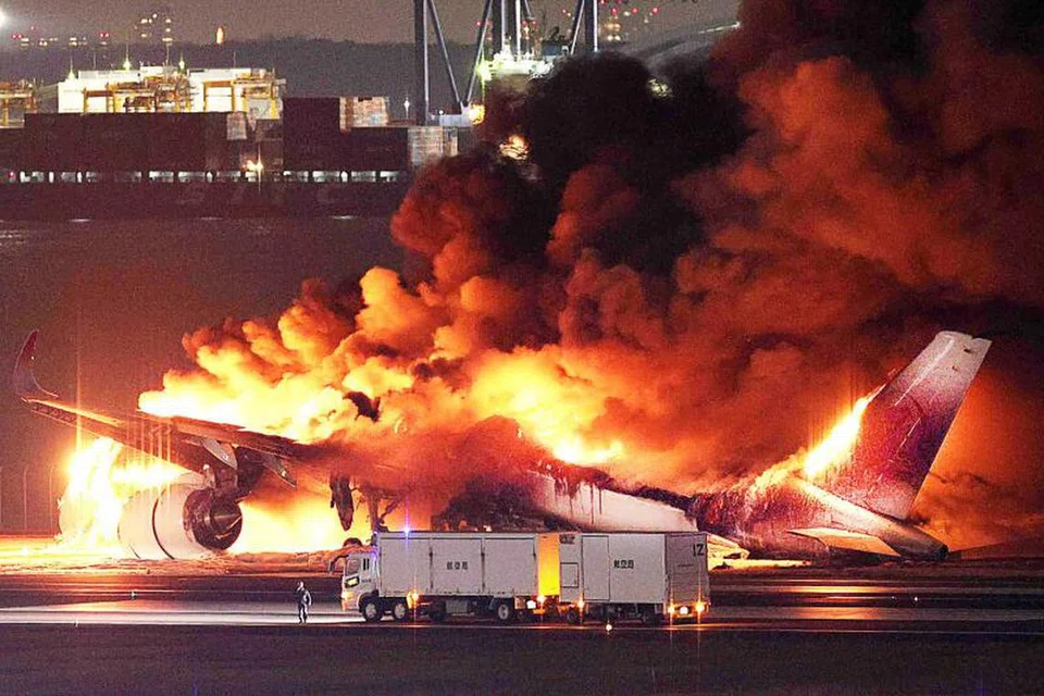 TERBAKAR: Sebuah pesawat Japan Airlines kelihatan terbakar sebelum ia tergelincir di landasan di lapangan terbang Haneda pada 2 Januari.