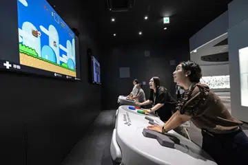 Pengunjung menikmati permainan sewaktu pratonton media muzium Nintendo yang baru di Kyoto pada 24 September.