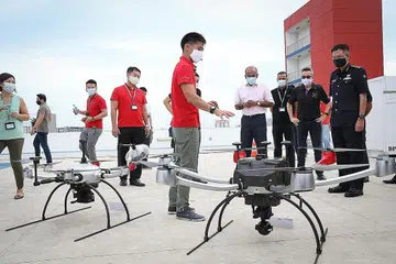 DETIK BERSEJARAH: Encik K Shanmugam (empat dari kanan) menyaksikan penerbangan sulung jarak jauh di Luar Garisan Penglihatan Visual (BVLOS) bagi kenderaan udara tanpa pemandu (UAV) HTX di Balai Bomba Tuas View semalam. - Foto BH oleh ONG WEE JIN