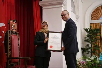 KENANGAN MANIS: Mejar (Bersara) Ridzwan Abu Bakar kelihatan menerima sijil daripada Presiden Halimah Yacob, sewaktu acara pelantikan dan makan malam pegawai Adikung Kehormat di Istana pada 16 Mei 2023. 