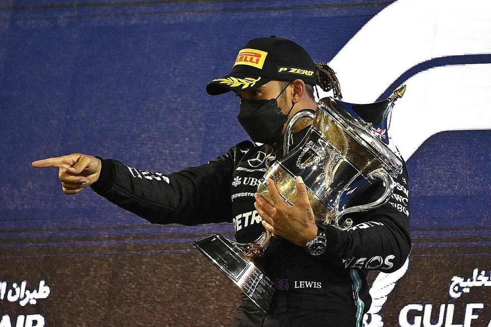 RANGKUL TROFI: Pemandu Mercedes Lewis Hamilton merangkul trofi Grand Prix Bahrain di Sakhir dengan mencatat kemenangan ke-11 musim ini dengan pemandu Red Bull Max Verstappen dan Alexander Albon di tempat kedua dan ketiga. - Foto AFP