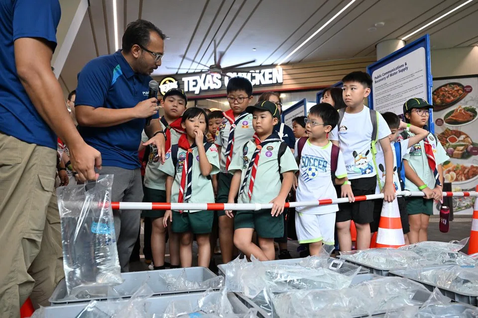 Pegawai agensi air negara PUB menunjukkan kepada sekumpulan kanak-kanak bagaimana air akan diagihkan kepada rakyat jika bekalan air di Singapura terganggu. Ia sebahagian acara Pertahanan Mutlak oleh Kementerian Pertahanan di Safra Choa Chu Kang pada 15 Februari 2025. (Gambar sisipan Encik Muhammad Syafiee Abdul Halim)
