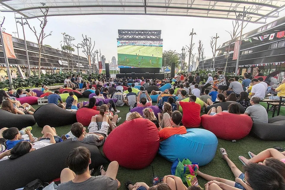 SELESA LAGI SERONOK: Pengunjung menikmati aksi-aksi Piala Dunia yang ditayangkan melalui skrin raksasa sempena Festival Bola Sepak Hab Sukan. - Foto HAB SUKAN SINGAPURA