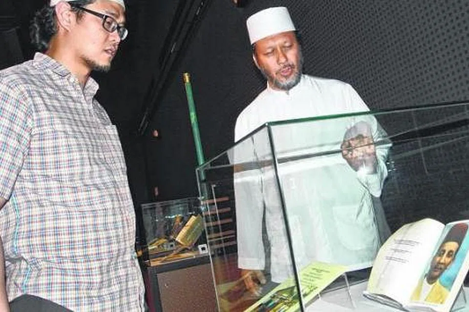 SUSURI KENANGAN LAMA: Cicit Sultanul Auliya Al-Arifbillah Syeikh Muhammad As-Suhaimi, Ustaz Abdul Hafiz Muhammad Taha As-Suhaimi (kanan), melihat khazanah warisan Masjid Maarof yang dipinjamkan Encik Helmie Sufie Jailani (kiri) sempena ceramah di TWM baru-baru ini. Antara khazanah itu ialah majalah Cahaya dan manaqib atau buku riwayat cendekiawan Islam. - Foto-foto JOHARI RAHMAT