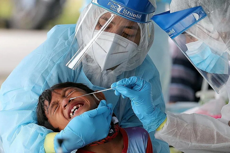 KES HARIAN MASIH TINGGI: Seorang pegawai perubatan menjalani ujian swab ke atas seorang budak di Klang, Malaysia, semalam. Kelmarin, Malaysia melaporkan 1,472 kes baru, menjadikan jumlah keseluruhan jangkitan di negara itu kepada 67,169. - Foto REUTERS