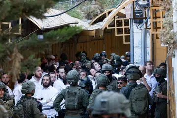 Askar Israel mengawasi sekumpulan penduduk haram Israel yang menyertai lawatan mingguan di Hebron, Tebing Barat yang diduduki, pada 11 Julai 2026. Ketika Israel meneruskan peluasan penempatan di wilayah Palestin yang diduduki, kumpulan hak asasi Ir Amim memberi amaran mengenai rancangan membina 450 unit rumah penempatan baharu di Umm Lison, Baitulmakdis Timur, yang dikhuatiri akan mengubah komposisi penduduk serta meningkatkan ketegangan antara penduduk Palestin dan pendatang haram  Israel.