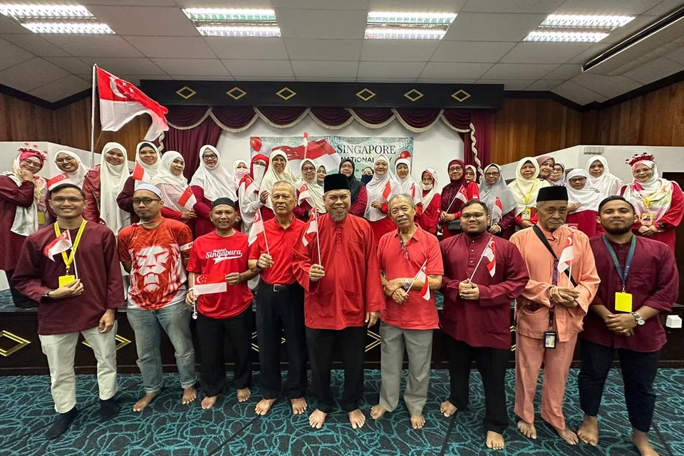 SUMBANGAN DIHARGAI: Encik Malik Majid (empat dari kiri);  Pengerusi Eksekutif Masjid Ar-Raudhah, Ustaz Mohamed Ali Atan (tengah); dan Encik Shuhaimi Maridin (empat dari kanan); bergambar ketika Majlis Memperingati Hari Kebangsaan (NDO) di Masjid Ar-Raudhah.