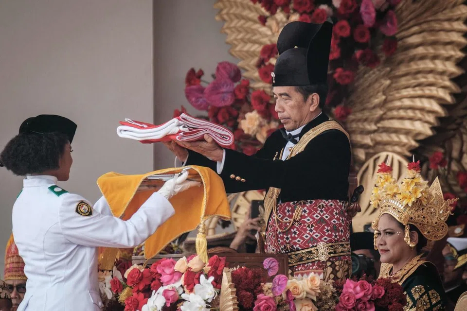 SAMBUT HARI KEBANGSAAN: Presiden Indonesia Joko Widodo (kanan) menyerahkan bendera negara sebelum ia dinaikkan semasa upacara memperingati Hari Kemerdekaan ke-78 negara itu di Istana Presiden di Jakarta pada Khamis.