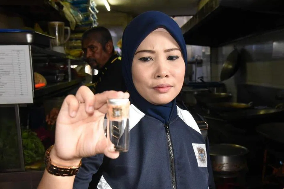 MENJIJIKKAN: Pegawai penguatkuasa Majlis Bandaraya Pulau Pinang menunjukkan najis tikus yang ditemui di restoran di Lebuh Chulia, Georgetown, Pulau Pinang. 