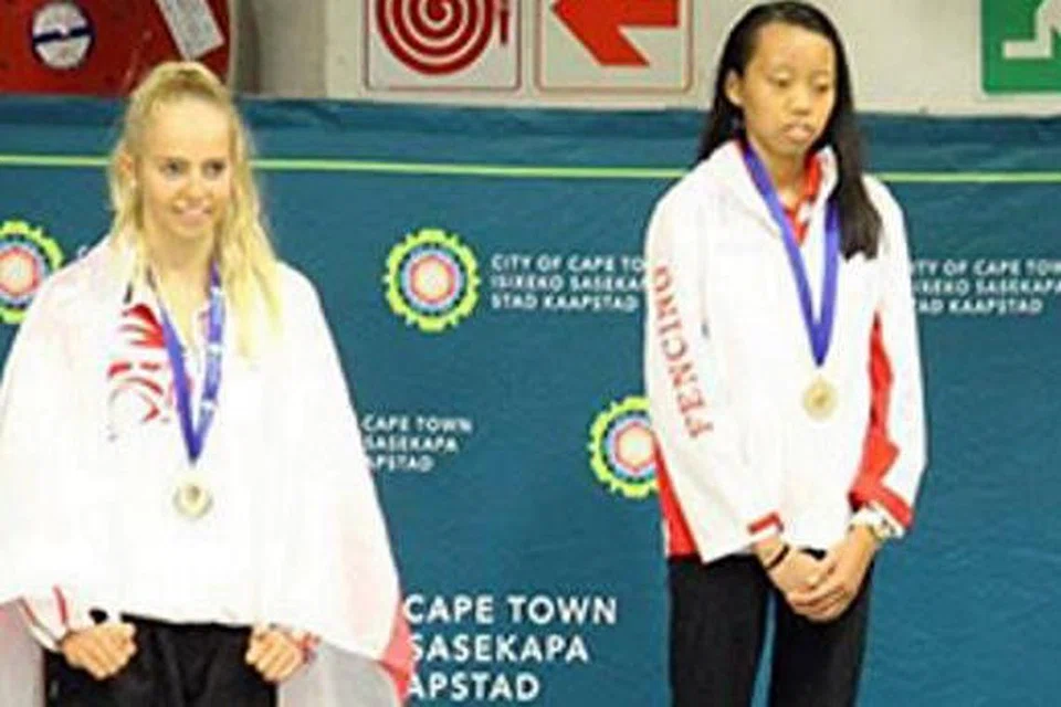 Saat membanggakan: kiria tikanah (kanan) mengibarkan bendera singapura dengan meraih kemenangan di cape town awal bulan ini. - Foto www.nswfencing.org.au