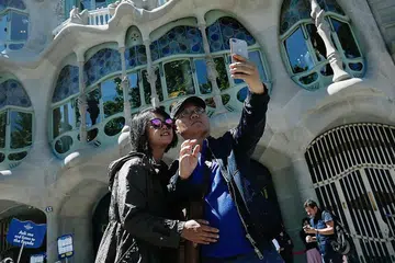 TARIK TERLALU RAMAI PELANCONG: Barcelona di Sepanyol, yang mempunyai sekitar 1.6 juta penduduk, sedang 'bertarung' dengan kemasukan sekitar 30 juta pelawat. Gambar menunjukkan pelancong sedang mengambil gambar di hadapan bangunan 'Casa Batllo' selepas muka hadapan bangunan ini menjalani baik pulih. - Foto AFP