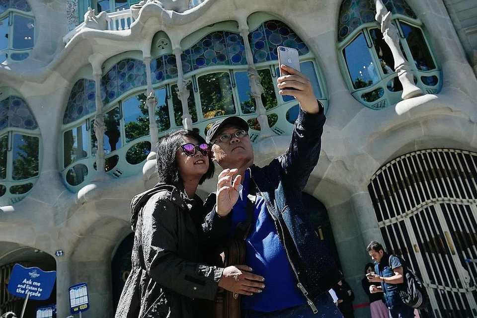 TARIK TERLALU RAMAI PELANCONG: Barcelona di Sepanyol, yang mempunyai sekitar 1.6 juta penduduk, sedang 'bertarung' dengan kemasukan sekitar 30 juta pelawat. Gambar menunjukkan pelancong sedang mengambil gambar di hadapan bangunan 'Casa Batllo' selepas muka hadapan bangunan ini menjalani baik pulih. - Foto AFP
