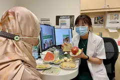 NASIHAT PILIHAN PEMAKANAN YANG BAIK: Cik Rachel Tan sedang memberi panduan tentang makanan sihat kepada seorang pesakit. - Foto TTSH