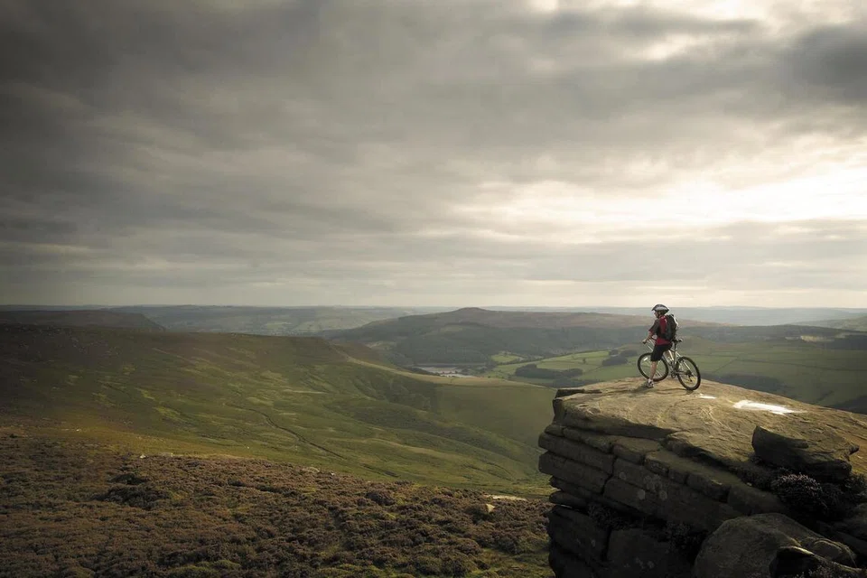 Seorang penunggang basikal menikmati pemandangan indah Yorkshire, England dari atas gunung (foto hiasan).