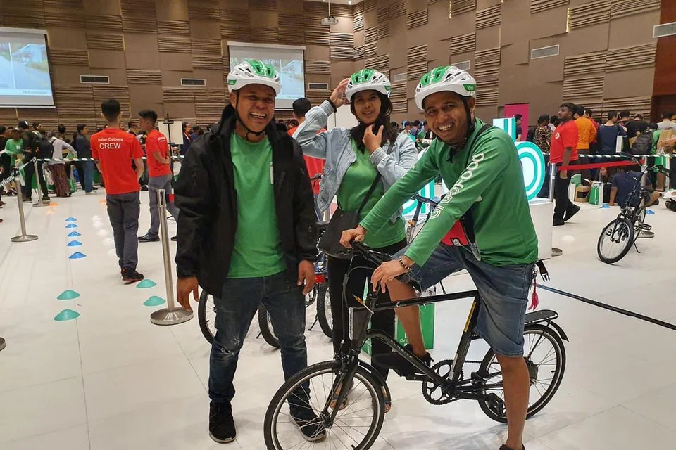 CUBA TOPI KELEDAR BARU: Pekerja penghantaran makanan Grab yang tamat menjalani kursus keselamatan anjuran Grab akan menerima topi keledar bijak baru, yang membolehkan mereka memberi isyarat lampu dan menunggang dengan lebih selamat. FOTO: NUR ADILAH MAHBOB