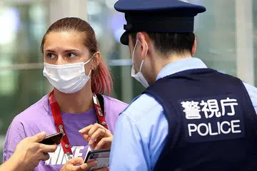 KESELAMATAN TERANCAM: Tsimanouskaya berbual dengan polis di Lapangan Terbang Haneda di Tokyo kelmarin. - Foto REUTERS
