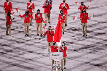 Pemain badminton Loh Kean Yew (kiri) dan pemain tenis meja Yu Mengyu (kanan) membawa bendera negara di majlis pembukaan Sukan Olimpik Tokyo pada 23 Julai. - Foto REUTERS