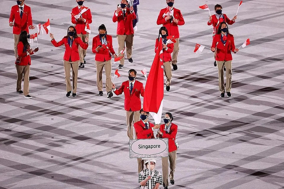 Pemain badminton Loh Kean Yew (kiri) dan pemain tenis meja Yu Mengyu (kanan) membawa bendera negara di majlis pembukaan Sukan Olimpik Tokyo pada 23 Julai. - Foto REUTERS