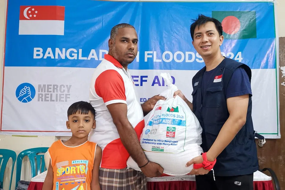 Pengarah Eksekutif Mercy Relief, Encik Muhammad Ashik (kanan) menyampaikan pek bantuan kepada keluarga terjejas akibat banjir di Bangladesh.