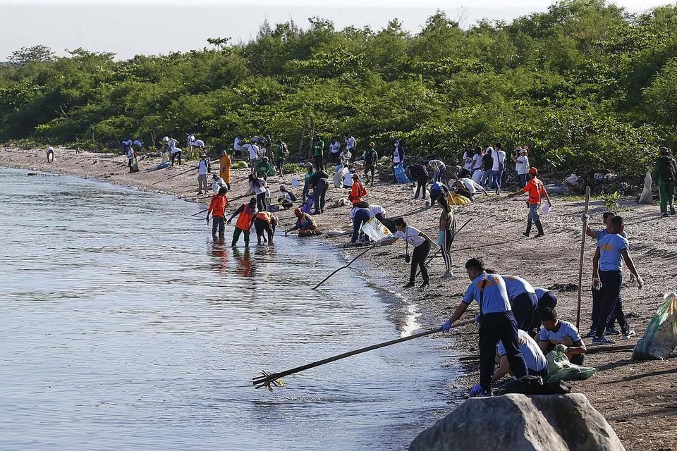 BERSIHKAN LAUT: Sukarelawan mengumpul bahan buangan yang terdampar di pantai Teluk Manila semasa kempen pembersihan pantai sempena Hari Lautan Sedunia di Manila, Filipina. - Foto EPA-EFE 