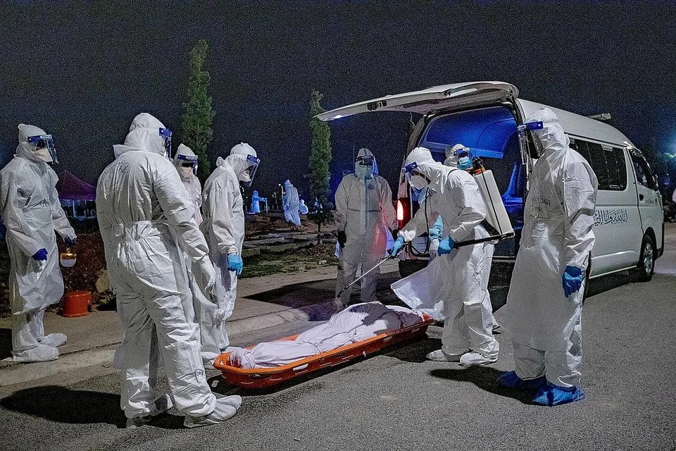 PANDEMIK COVID-19: Peningkatan kes jangkitan dan kematian akibat Covid-19 telah menjejas prestasi ekonomi Malaysia hingga mengakibatkan syarikat penarafan kredit antarabangsa, Fitch Solutions membuat semakan semula unjuran Keluaran Dalam Negara Kasar (KDNK) Malaysia. Gambar menunjukkan sekumpulan petugas perubatan pada 16 Julai lalu melakukan sanitasi ke atas jenazah pesakit koronavirus di Kuala Lumpur dan kemudian membakar kesemua alat pelindung diri yang digunakan mereka demi mencegah penularan virus. - Foto BH oleh YUSOF ASYRAF