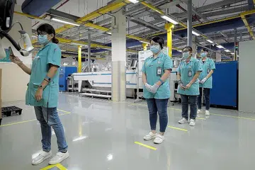 LEBIH RAMAI PEKERJA BUKAN PMET DI INDUSTRI TERJEJAS COVID-19: Pekerja menjaga jarak selamat sambil membuat catatan masuk dan keluar di kilang PepperL + Fuchs di Ayer Rajah Mei lalu. Industri lebih terjejas oleh Covid-19 mempunyai jumlah pekerja bukan PMET lebih tinggi. - Foto fail