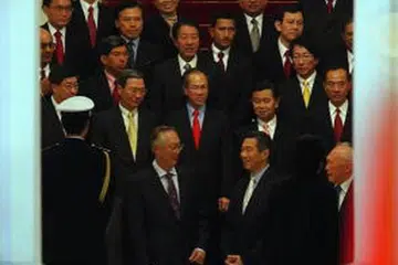 Perdana Menteri Singapura Encik Lee Hsien Loong (tengah) bersama pasukan Kabinetnya bersiap untuk bergambar pada upacara angkat sumpah pada 2004. Beliau dilihat bersama dua mantan Perdana Menteri iaitu Encik Goh Chok Tong (kiri), dan Encik Lee Kuan Yew.