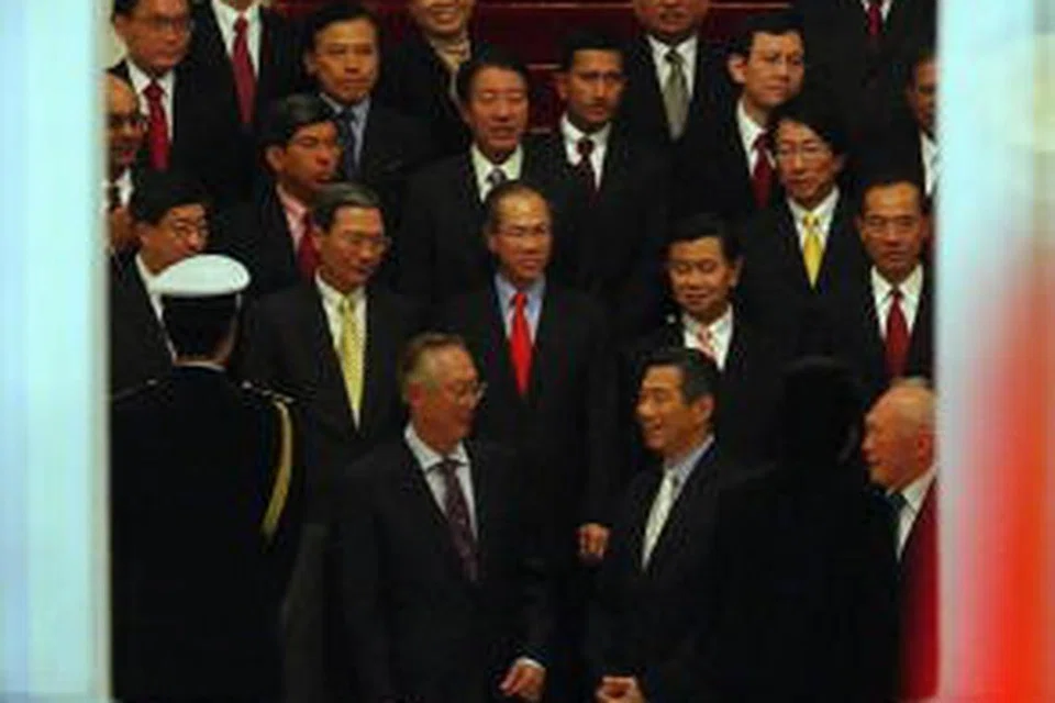 Perdana Menteri Singapura Encik Lee Hsien Loong (tengah) bersama pasukan Kabinetnya bersiap untuk bergambar pada upacara angkat sumpah pada 2004. Beliau dilihat bersama dua mantan Perdana Menteri iaitu Encik Goh Chok Tong (kiri), dan Encik Lee Kuan Yew.