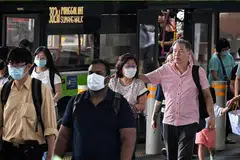MASIH DIGUNAKAN: Beberapa penumpang di Pusat Tukaran Bas Punggol (gambar atas) dan penumpang MRT masih lagi menggunakan pelitup pada 13 Februari. - Foto-foto ST