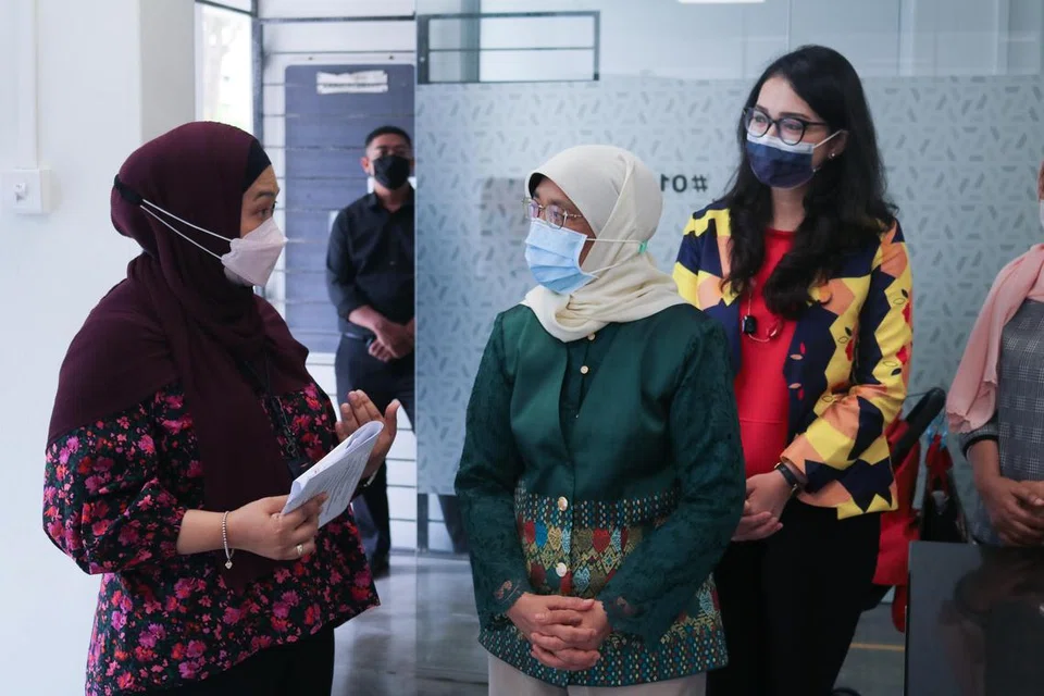 PRIHATIN TERHADAP WANITA: Mantan Presiden Halimah Yaacob (tengah), yang ditemani Presiden PPIS, Cik Hazlina Abdul Halim (kanan), kelihatan berbicara bersama pekerja sosial utama PPIS, Cik Nasriah Nasir (paling kiri), semasa lawatannya ke Pusat Khidmat Keluarga PPIS (Barat) pada 2021. 