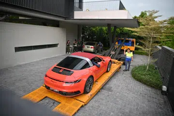 PENGUBAHAN WANG HARAM: Kereta merah Porsche 911 Targa ialah antara empat kereta mewah ditarik keluar dari sebuah Banglo Kelas Baik (GCB) di Third Avenue di Bukit Timah. Keempat-empat kereta itu, yang dikaitkan dengan kes pengubahan wang haram terbesar di Singapura, bernilai lebih $4.7 juta.
