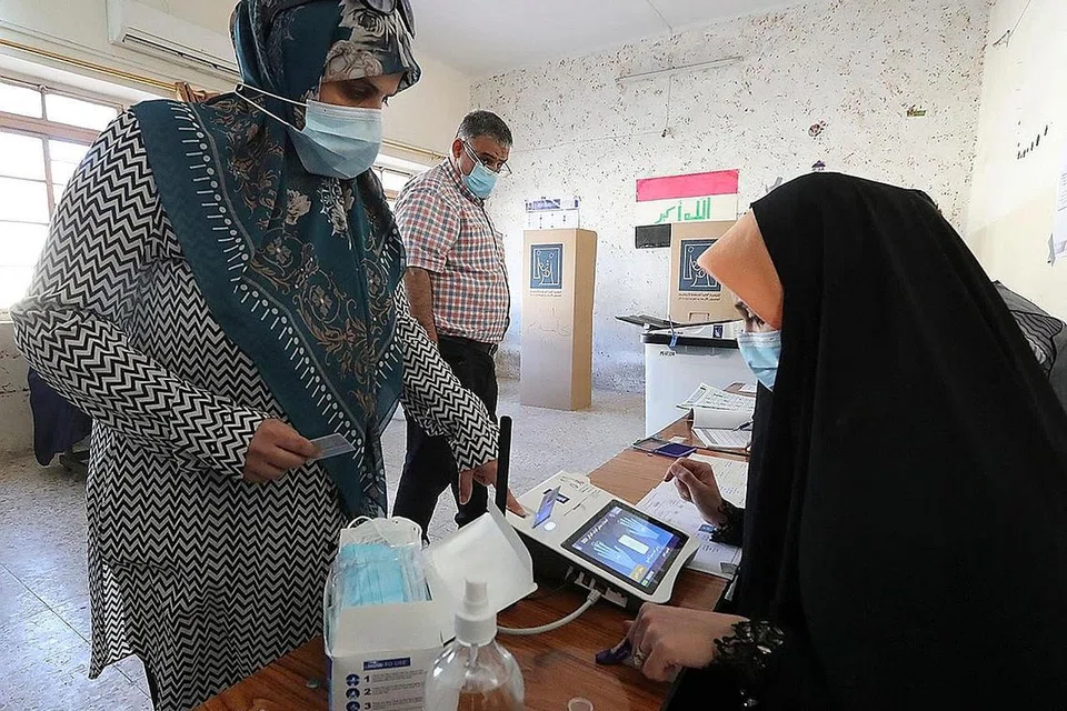 TAMPIL MENGUNDI: Seorang wanita Iraq mendaftar untuk mengundi di pusat pengundian di Baghdad semalam. - Foto AFP