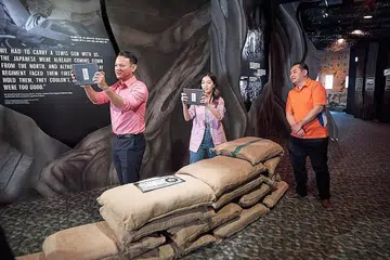 TEROKA PAMERAN: Encik Zaqy (kiri) dibawa meneliti pameran tetap terbaru bertajuk 'Through the Lens of Time' bersama pempengaruh Annette Lee dan pemandu pameran Tan Yong Wei di SDC semalam. Dalam ucapannya, Encik Zaqy menekankan kepentingan perpaduan dalam mengharungi gelombang cabaran seperti penularan wabak Sars pada 2003 dan kini pandemik Covid-19. - Foto MINDEF