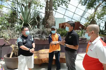 BANTUAN BAGI PEKERJA: Setiausaha Agung NTUC Ng Chee Meng (dua dari kanan) dan Penolong Setiausaha Agung NTUC Zainal Sapari (kanan) bertemu beberapa benefisiari Dana Penjagaan NTUC (Covid-19) di Gardens by the Bay pada November 2020. - Foto NTUC